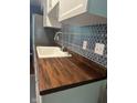 Beautiful kitchen with white cabinets, wooden countertop, stainless steel appliances and modern backsplash at 8540 E 37Th Pl, Indianapolis, IN 46226