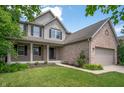 Attractive two-story home showcasing a welcoming front porch and a beautiful lawn with mature trees at 8578 Nolan Dr, Fishers, IN 46038