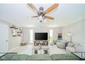 Comfortable living room with a large sectional couch, ceiling fan, and built-in shelving at 901 N Greenbriar Rd, Muncie, IN 47304