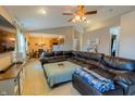 Open living room with plush leather sectional, ceiling fan and a view into the kitchen and dining area at 939 Arabian Way, Bargersville, IN 46106