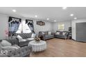 Elegant living room features wood floors, recessed lighting, and matching grey sofas at 951 Curlew Ln, Greenwood, IN 46143