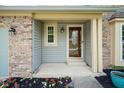 Inviting entryway with a decorative glass door, stylish brick accents, and manicured flower beds at 10751 Sheffield Ct, Fishers, IN 46038
