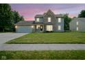 Charming two-story home with a well-maintained lawn at dusk with vibrant sky at 10751 Sheffield Ct, Fishers, IN 46038