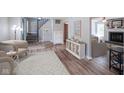 Spacious living room featuring hardwood floors, staircase, and a cozy fireplace at 10751 Sheffield Ct, Fishers, IN 46038