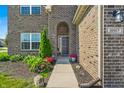 Inviting front entry with a decorative door, manicured landscaping, and well-maintained brick facade at 10917 Hunter Lake Ln, Indianapolis, IN 46239