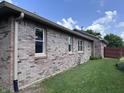 Angle shot of a beautiful brick house with white framed windows and green lawn at 1206 Brownswood Dr, Brownsburg, IN 46112