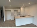 Bright kitchen showcasing white cabinets, a center island with a sink, and recessed lighting at 1436 Aster Dr, Shelbyville, IN 46176