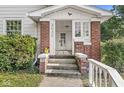 Inviting front porch with brick columns, a white railing, and space for outdoor decoration at 2020 N B St, Elwood, IN 46036