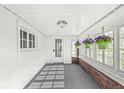 Enclosed porch with charming windows, potted plants, and a smooth transition from indoors to the outside at 2020 N B St, Elwood, IN 46036