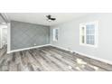Light-filled living room with modern flooring, a unique accent wall, and neutral paint at 2136 Ringgold Ave, Indianapolis, IN 46203