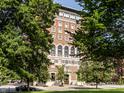 Exterior shot of brick building framed by lush green trees at 350 N Meridian St # 606/607, Indianapolis, IN 46204