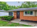 Charming single-story brick home with a dark front door flanked by two windows and tidy landscaping at 3513 Ireland Dr, Indianapolis, IN 46235