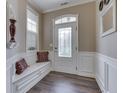 Elegant foyer features a decorative front door, built-in bench, and hardwood floors at 3962 Kristi Way, Greenwood, IN 46142