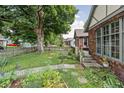 Side yard showing nice lawn and landscaping details, and a partial view of the home's brick exterior at 4901 N Kenwood Ave, Indianapolis, IN 46208