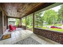 Relaxing covered porch with brick accents, tile flooring, and neighborhood views at 5144 N College Ave, Indianapolis, IN 46205