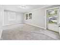 Bright living room features neutral paint and carpeting at 602 W 34Th St, Anderson, IN 46013