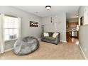 Cozy living room features neutral tones, carpeted floor, a couch, window and open floor plan into kitchen at 6126 Navy Cir, Indianapolis, IN 46221