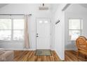 Inviting entryway with hardwood floors, a white front door with glass panes, and neutral walls at 6142 Evanston Ave, Indianapolis, IN 46220