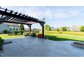 Outdoor patio with pergola, stone fire pit, and views of the pond and backyard at 6664 Kara Ln, Brownsburg, IN 46112