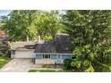 Blue ranch-style home with stone accents, a front lawn, and mature trees at 6739 Westdrum Rd, Indianapolis, IN 46241