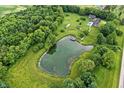 Stunning aerial view of a pond, mature trees and the backyard pool area at 750 N 500 W, Lebanon, IN 46052