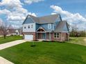 Attractive two-story home with brick accents, blue siding, and a well-maintained lawn at 7604 Brownstone Ct, Greenfield, IN 46140