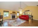 Bright living room with a fireplace, large rug, vaulted ceiling, and a view to the kitchen at 767 Harvest Ridge Dr, Avon, IN 46123