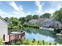 View of a serene waterfront backyard setting, complete with lush greenery and multiple houses at 7846 Park North Cir, Indianapolis, IN 46260