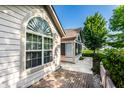 Detailed home exterior with a brick patio, large arched window, and view of the screened-in porch at 7919 Cool Hollow Pl, Indianapolis, IN 46237