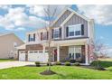 Beautiful home with a brick and siding exterior, a well-manicured lawn, and inviting front porch at 9916 Gallop Ln, Fishers, IN 46040