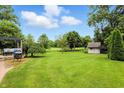 Large backyard with mature trees and a shed, perfect for outdoor activities and relaxation at 1013 Chapman Blvd, Greenfield, IN 46140