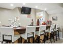 Basement bar with stylish white barstools and a TV, great for entertaining guests at 1013 Chapman Blvd, Greenfield, IN 46140