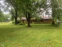 Charming single-story brick home on a lush, green lawn with mature trees providing shade at 106 N 300 W, Greenfield, IN 46140