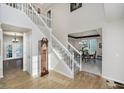 Inviting foyer featuring a staircase, wood floors, and view into the formal dining room at 13214 Dunwoody Ln, Carmel, IN 46033