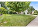 A lush front yard with mature trees and green grass provides excellent curb appeal to this lovely home at 13470 Shakamac Dr, Carmel, IN 46032