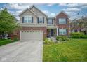 Charming two-story home featuring a brick and vinyl exterior, attached two-car garage, and well-manicured lawn at 13884 Wendessa Dr, Fishers, IN 46038