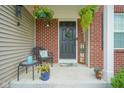 Cozy front porch featuring a wicker chair, decorative pillows, hanging flower baskets, and a 'Home Sweet Home' sign at 13884 Wendessa Dr, Fishers, IN 46038