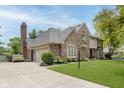 Brick home featuring an attached two-car garage, well-maintained lawn, and mature landscaping at 1393 Stoney Creek Cir, Carmel, IN 46032