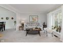 Inviting living room featuring neutral decor, plush carpeting, and a bright window with sheer curtains at 1393 Stoney Creek Cir, Carmel, IN 46032