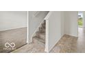 Inviting entryway featuring carpeted stairs and neutral-toned tile flooring at 1456 Willow Tree Ln, Sheridan, IN 46069