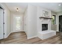 Bright foyer featuring wood-look flooring, a fireplace, and a glass front door at 1540 Roanoke Dr, Zionsville, IN 46077