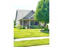 Inviting home featuring a covered front porch with attractive landscaping and a lush green lawn at 1688 Magnolia Dr, Greenwood, IN 46143