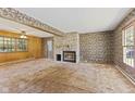Spacious living room featuring a stone fireplace, unique wallpaper, and ample natural light at 1841 Shady Ln, Martinsville, IN 46151