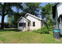 Exterior view of a cozy home with a small yard and some landscaping, including a bush near the house at 2025 Fairview St, Anderson, IN 46016