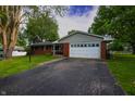 Charming single-story brick home with a well-manicured lawn and long driveway at 207 E Waterbury Rd, Indianapolis, IN 46227