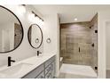 Bathroom featuring a double sink vanity with modern faucets and a stylish walk-in shower with tiled walls at 214 Handley St, Indianapolis, IN 46222