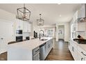 Modern, eat-in kitchen with large island, stainless appliances, sleek white cabinetry and designer light fixtures at 214 Handley St, Indianapolis, IN 46222
