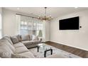 Bright living room featuring a comfortable L-shaped sofa, sleek glass coffee table and large flat screen TV at 214 Handley St, Indianapolis, IN 46222
