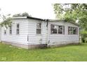 View of the side exterior highlighting its foundation, windows, and siding, surrounded by greenery at 220 S 2Nd St, Summitville, IN 46070