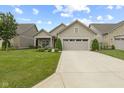 Landscaped front yard featuring a well-maintained lawn, flowering shrubs and a two-car garage at 2246 Heather Glen Way, Franklin, IN 46131
